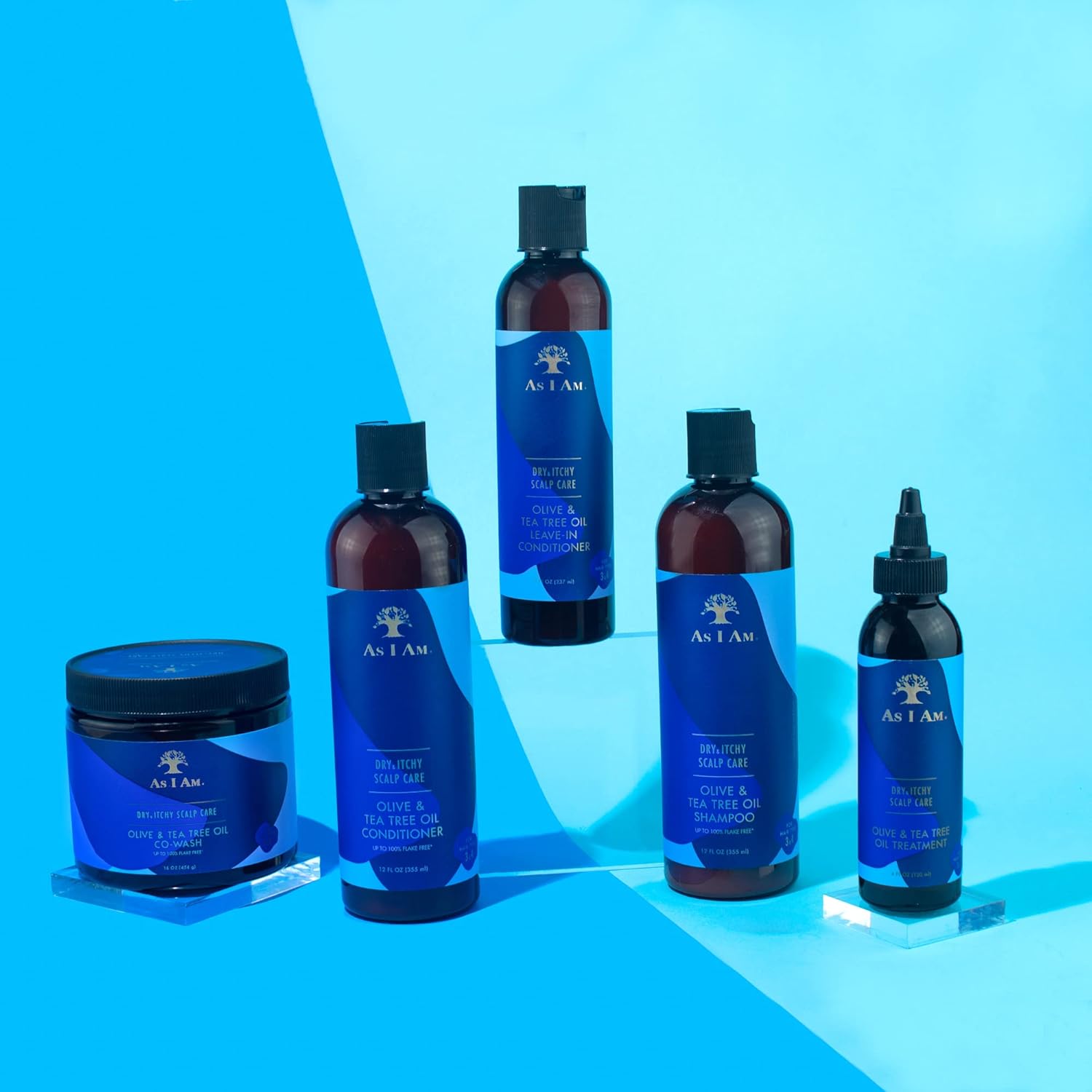 Fem produkter fra As I Am Dry & Itchy Scalp Care-serien er arrangeret på en lyseblå overflade. 