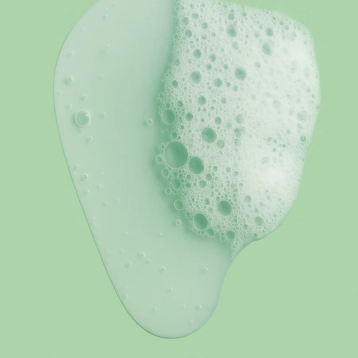 Let skummende ansigtsrens i flydende form med mild konsistens på lysegrøn baggrund.