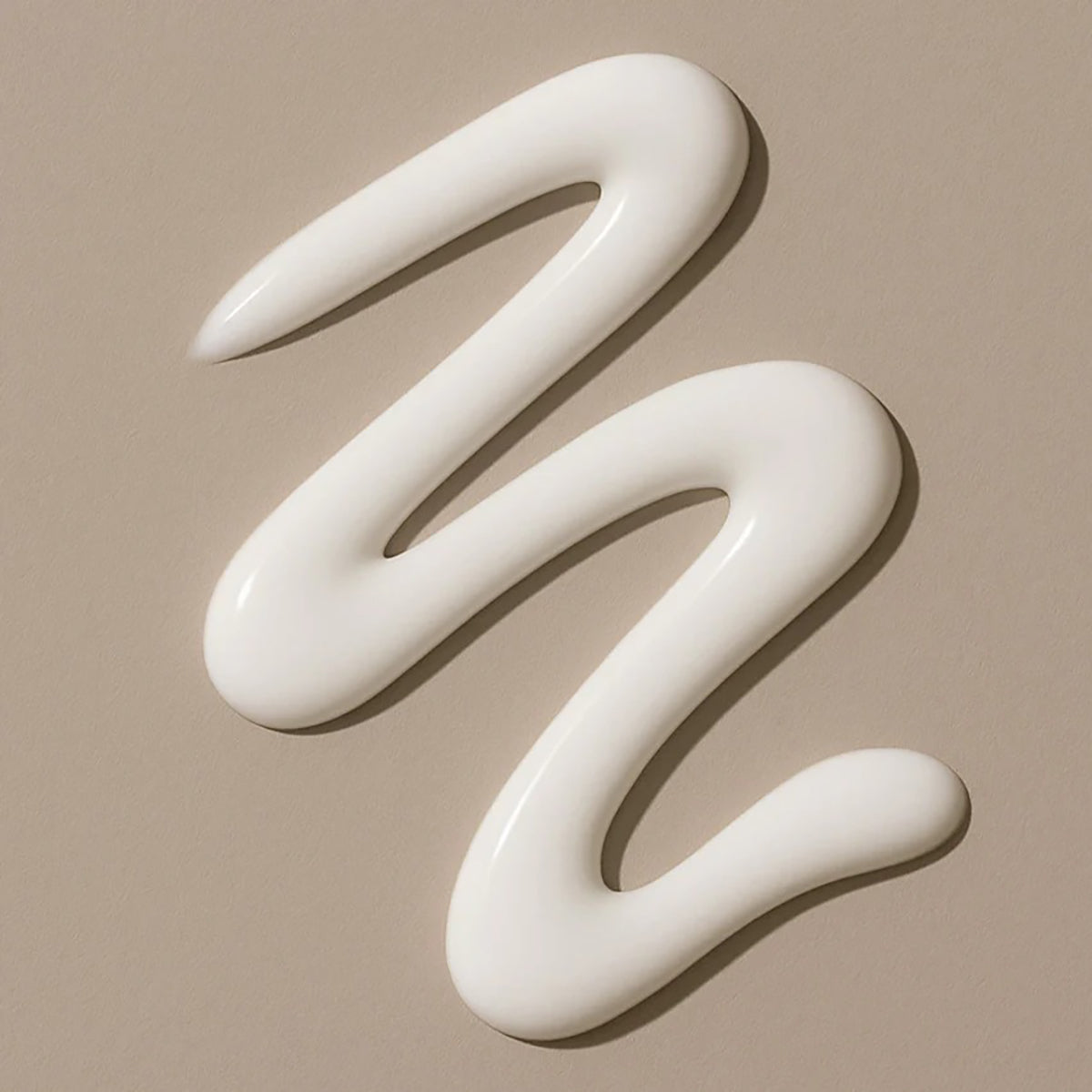 Lys, cremet tekstur af Bali Gents Energizing Face Cream 50ml swirlet på beige baggrund.