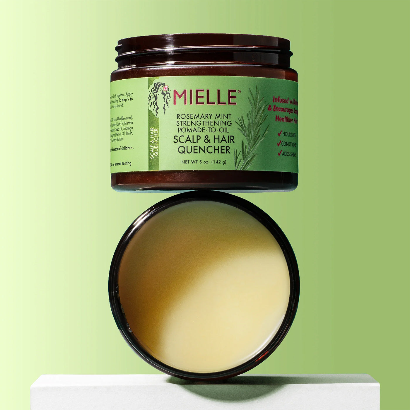 Åben beholder Mielle Rosemary Mint Pomade-to-Oil Scalp & Hair Quencher 142gr med lysegrøn baggrund, viser nærende balm til hår og hovedbund.