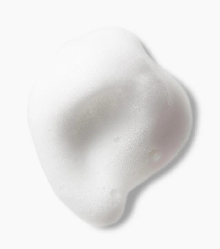 Blød, hvid skumtekstur af Not Your Mother's Curl Talk Refreshing Foam 236ml vist på lys baggrund.