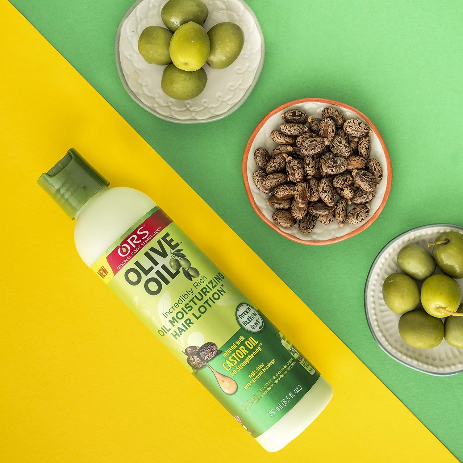 ORS Olive Oil Incredibly Rich Oil Moisturizing Hair Lotion omgivet af oliven og castorfrø, der illustrerer de naturlige ingredienser.