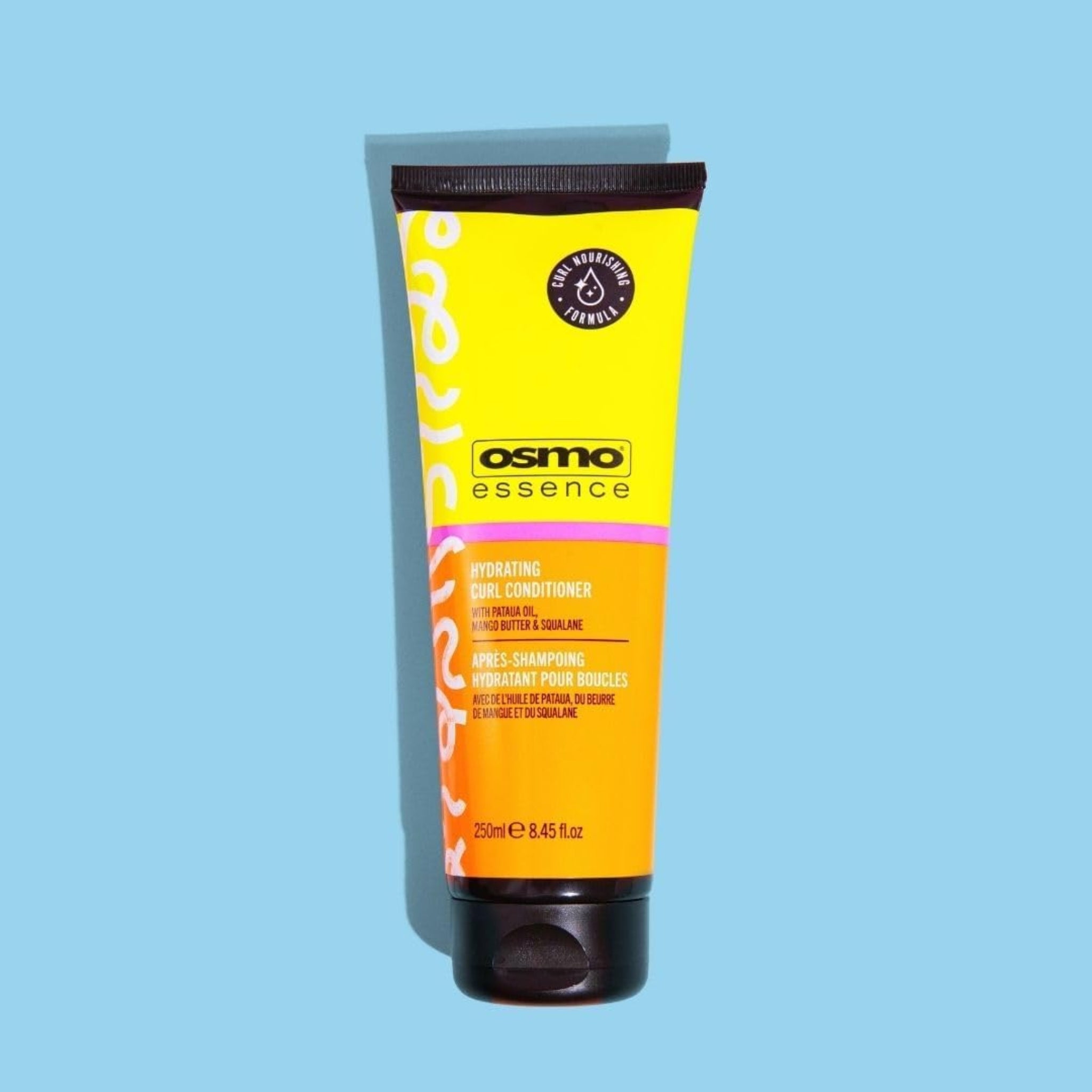 Osmo Essence Hydrating Curl Conditioner tube i gul og orange, 250 ml, på lyseblå baggrund.
